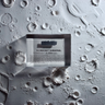 Close-up piece of V-2 rocket shrapnel embedded in clear acrylic. The fragment is metallic and jagged, with a distinctive shape that highlights its history from World War II rocket warfare.